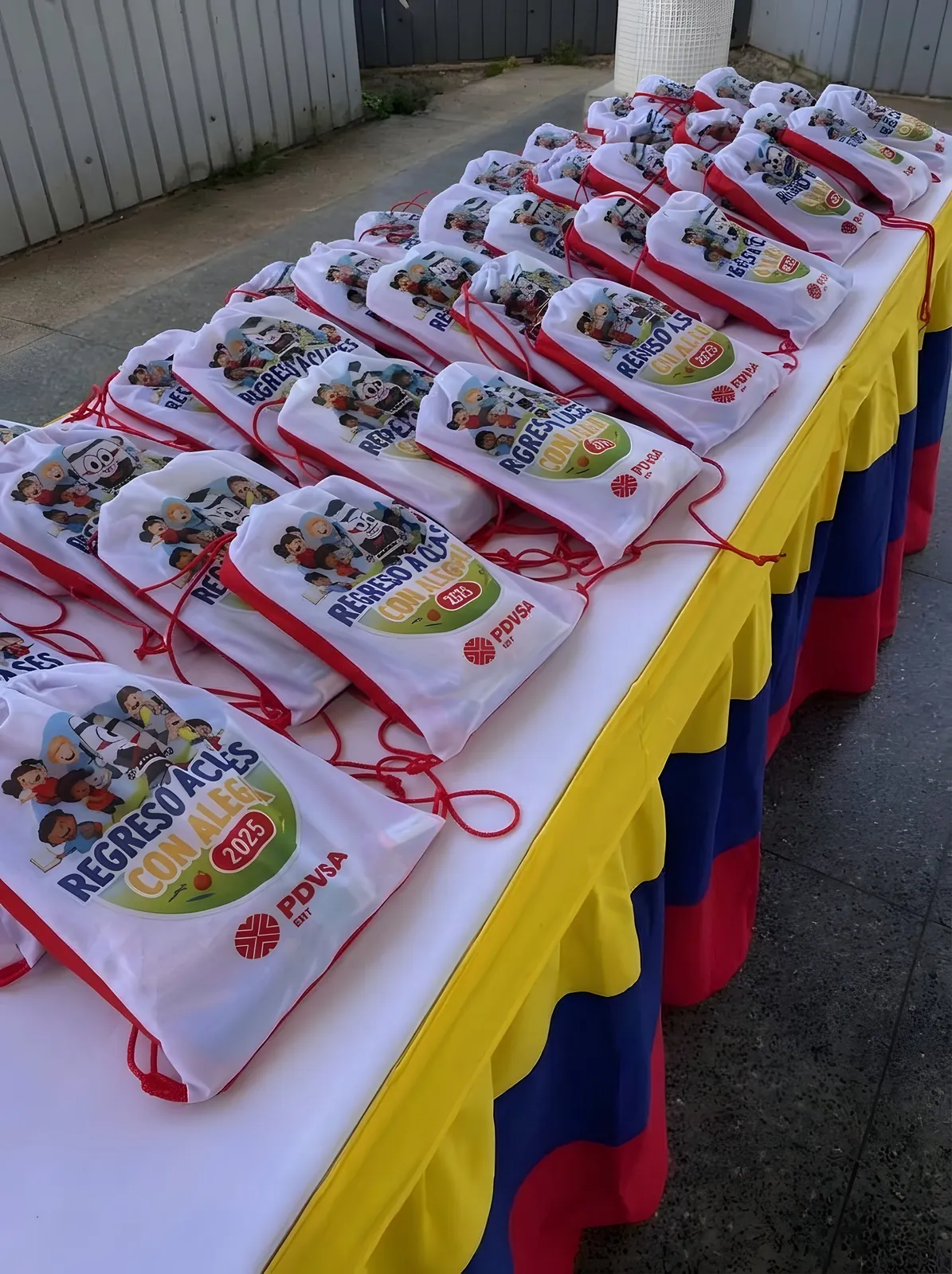 Morrales blancos estampados con «Regreso a Clases con Alegría 2025».